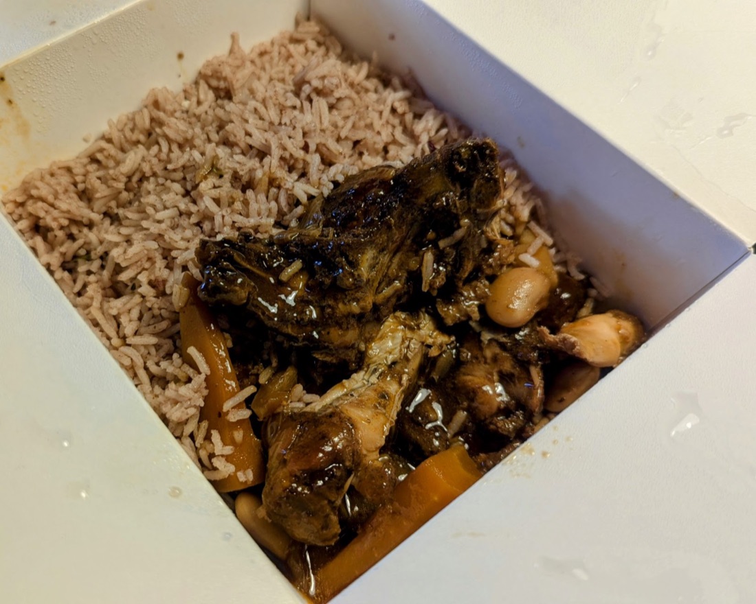 Jerk chicken with rice and peas in a takeaway box